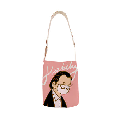 Tote bag with a design of a person wearing a face mask and the word 'Healthy' on a pink background.